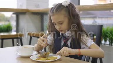 学生小学穿着校服坐在学校食堂的一张桌子东西。